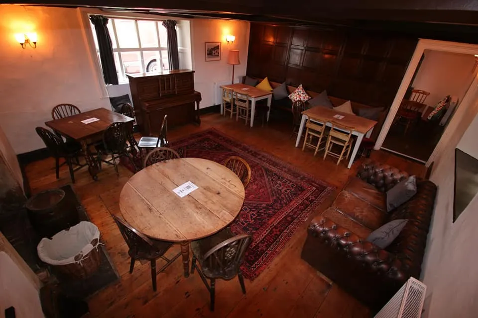 Timber panelling, sofas and wooden tables inside The Butcher’s Hook